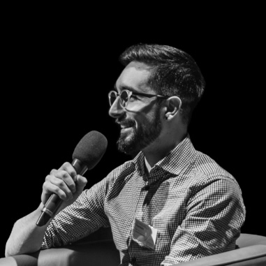 Damian speaking into a microphone on stage